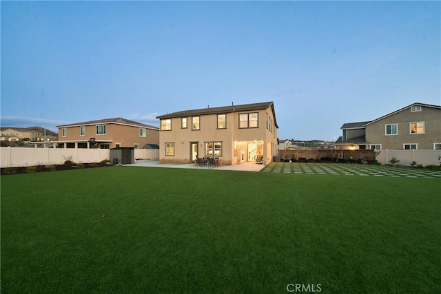 rear view of house with a lawn and a patio area