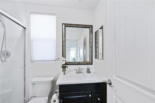 bathroom with vanity, a shower with shower door, and toilet