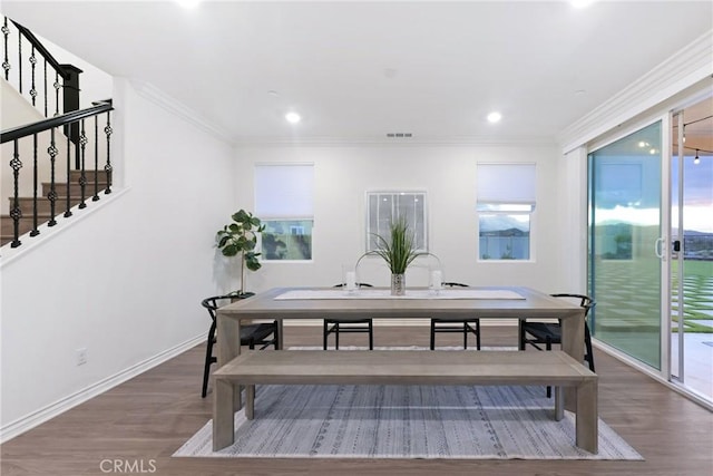 dining room featuring crown molding, plenty of natural light, and hardwood / wood-style flooring