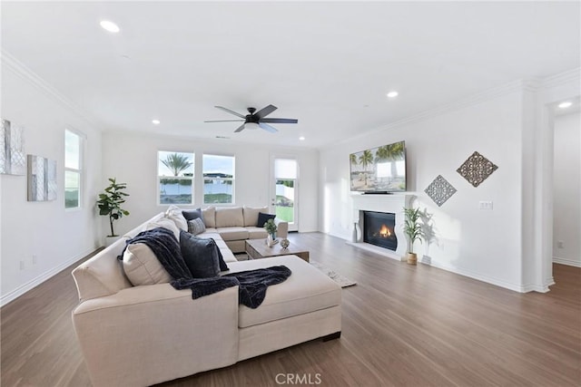 living room with wood-type flooring, ornamental molding, and a wealth of natural light