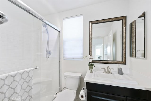 bathroom featuring vanity, an enclosed shower, and toilet