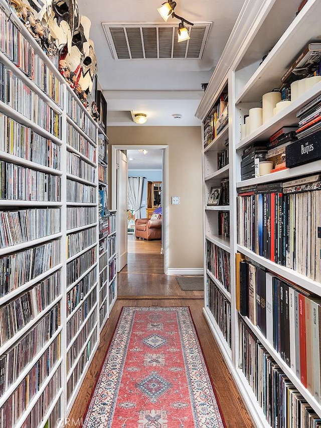 corridor featuring dark wood-type flooring, visible vents, and baseboards