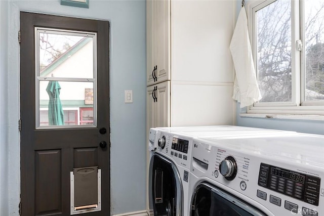 laundry area featuring washing machine and clothes dryer and cabinet space