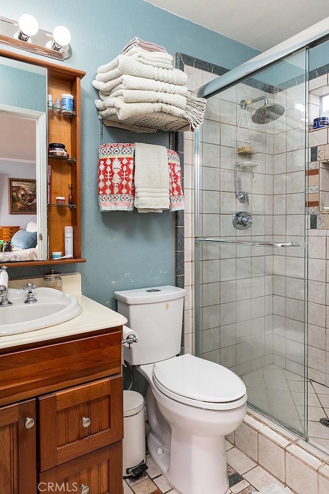 bathroom with a stall shower, vanity, and toilet