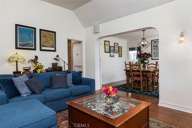 living area with arched walkways, lofted ceiling, a notable chandelier, baseboards, and dark wood finished floors