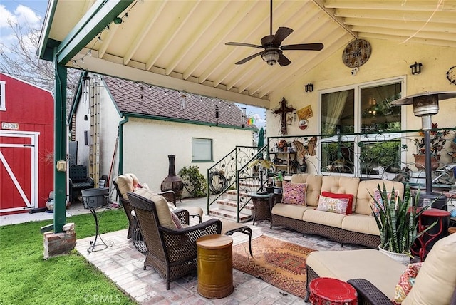 view of patio featuring a ceiling fan, a storage unit, an outdoor structure, and an outdoor hangout area