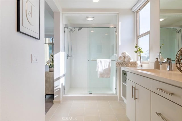 full bath with a stall shower, vanity, and tile patterned floors