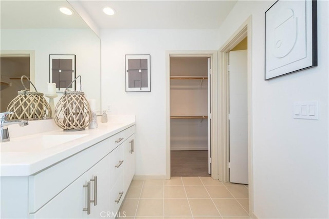 bathroom featuring recessed lighting, a sink, tile patterned floors, double vanity, and a walk in closet