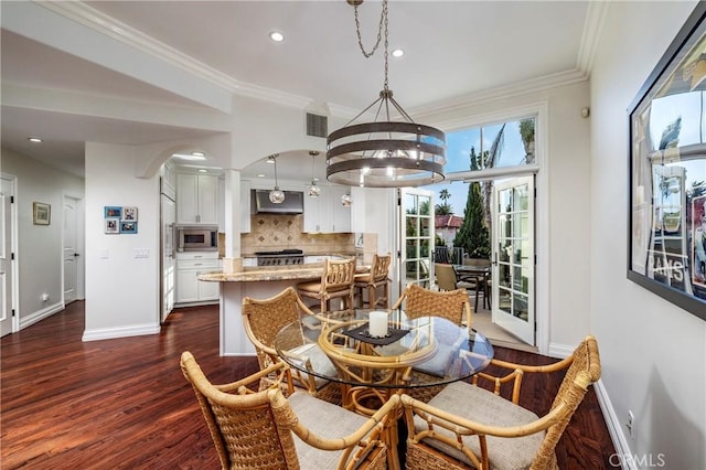 dining room with crown molding, dark hardwood / wood-style floors, and a notable chandelier