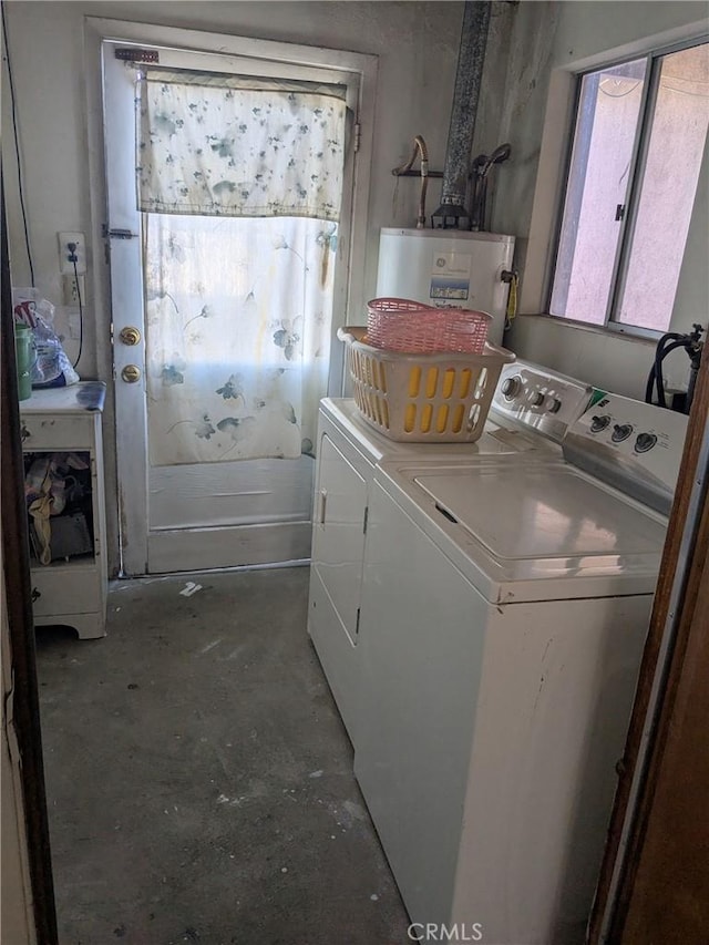 washroom featuring laundry area, water heater, and washing machine and clothes dryer