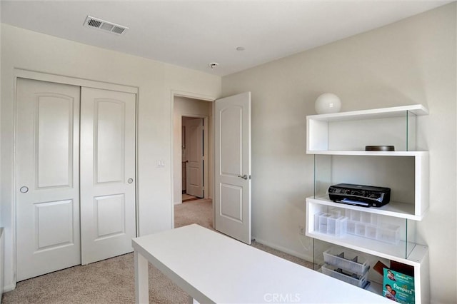 office featuring baseboards, visible vents, and light carpet