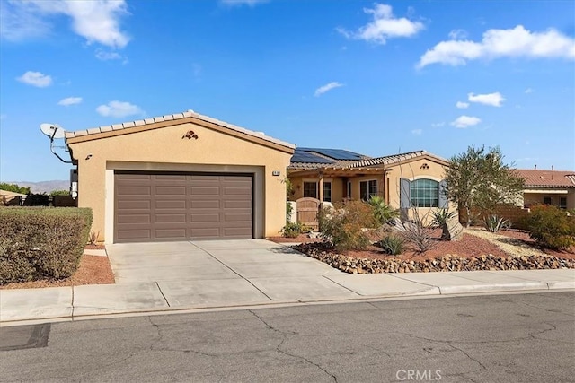 view of front of home with a garage and solar panels