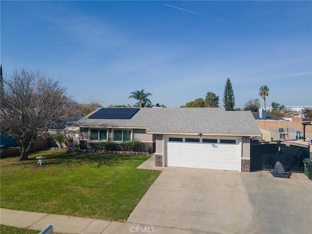 ranch-style home with driveway, solar panels, an attached garage, a front yard, and stucco siding