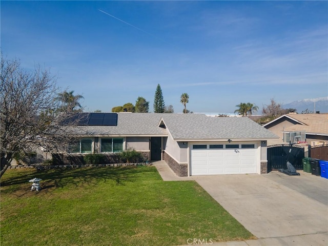 ranch-style house with a garage, solar panels, driveway, stucco siding, and a front yard