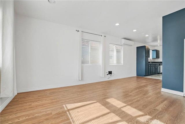 empty room with light hardwood / wood-style floors and a wall unit AC