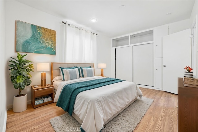 bedroom with light hardwood / wood-style flooring and a closet