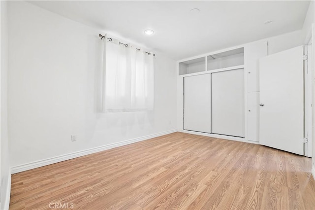 unfurnished bedroom featuring light hardwood / wood-style flooring and a closet