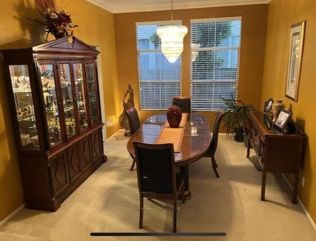 dining area featuring ornamental molding, light carpet, and an inviting chandelier