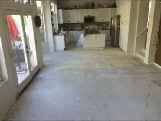 kitchen with unfinished concrete flooring, a center island, freestanding refrigerator, and white cabinetry