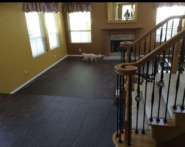 interior space featuring stairs, a fireplace, baseboards, and wood finished floors
