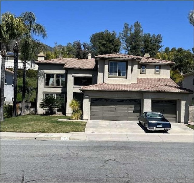 view of front of property featuring driveway, a tile roof, a front yard, and stucco siding