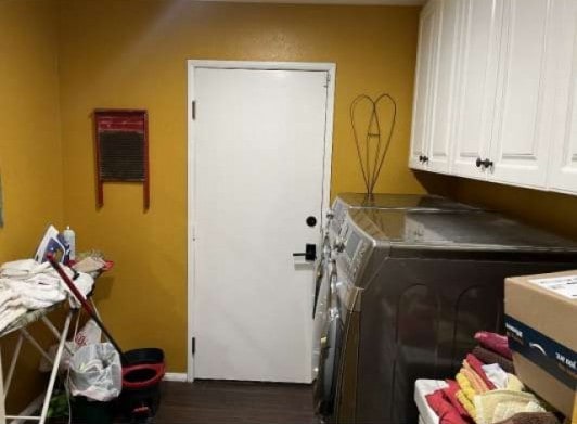 laundry room featuring cabinet space, separate washer and dryer, and dark wood finished floors
