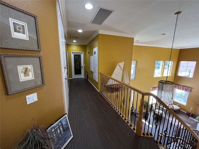 corridor featuring wood finished floors, visible vents, an upstairs landing, baseboards, and ornamental molding