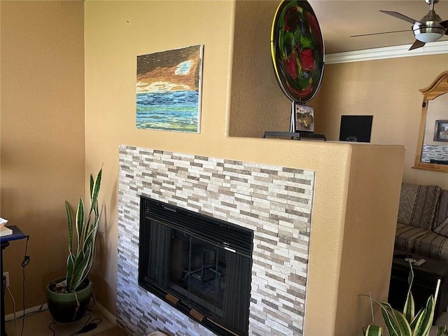 details with ornamental molding, a glass covered fireplace, and a ceiling fan