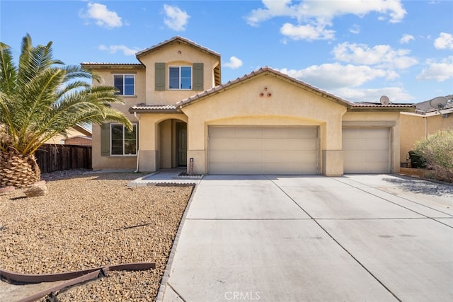 mediterranean / spanish-style home with a garage, concrete driveway, fence, and stucco siding