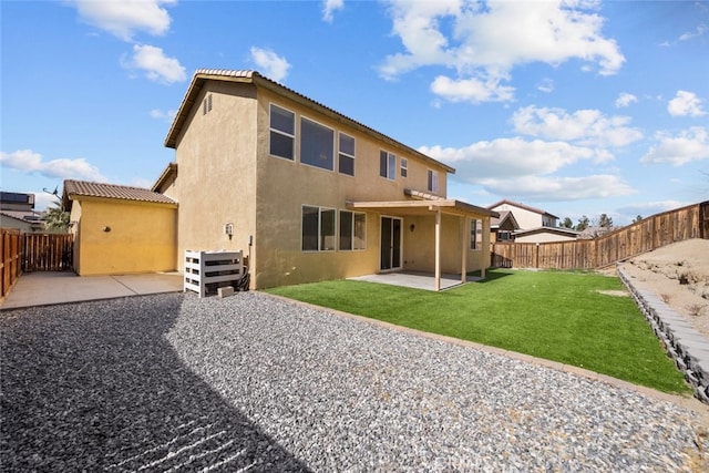 rear view of property with a yard, a patio area, a fenced backyard, and stucco siding