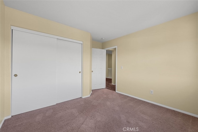 unfurnished bedroom featuring a closet, carpet flooring, and baseboards