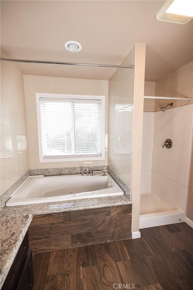 bathroom with vanity, hardwood / wood-style flooring, and tiled shower