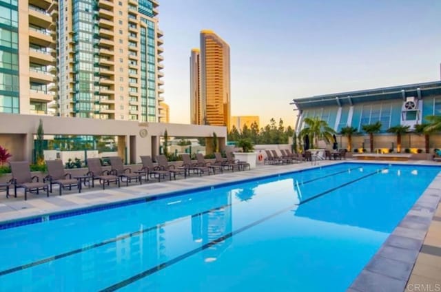 pool at dusk featuring a patio area