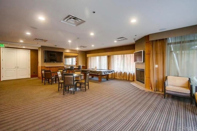 playroom featuring a large fireplace and carpet floors