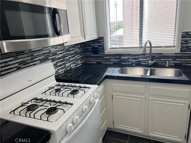 kitchen with white cabinetry, tasteful backsplash, sink, and white gas range oven