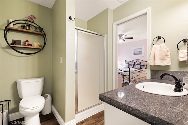 bathroom featuring toilet, vanity, an enclosed shower, and wood-type flooring