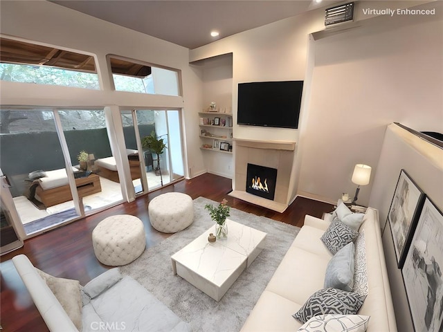 living room with a tiled fireplace and hardwood / wood-style floors