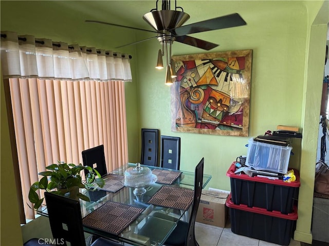 tiled dining space with ceiling fan