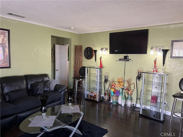 living room featuring dark hardwood / wood-style flooring and a textured ceiling