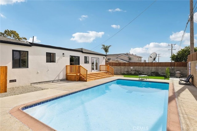 view of swimming pool with a diving board and a patio area