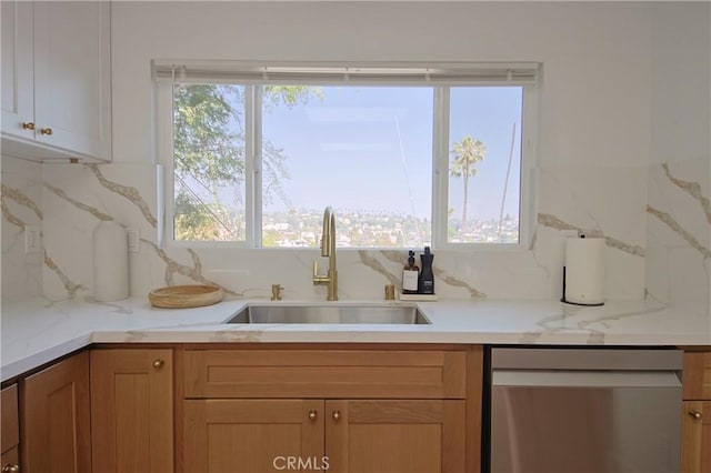kitchen featuring tasteful backsplash, sink, light stone counters, and stainless steel dishwasher