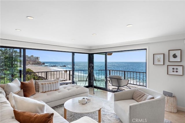 living room with crown molding, a water view, and a beach view