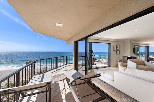 balcony with a water view, outdoor lounge area, and a view of the beach