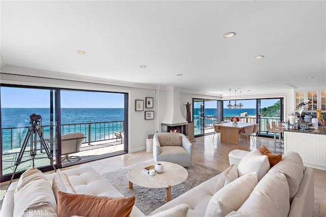 living room featuring a water view, crown molding, and a notable chandelier