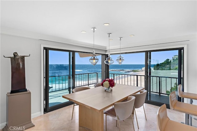 dining room with a water view, a view of the beach, and light tile patterned floors