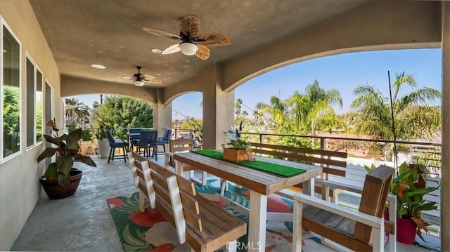 balcony featuring outdoor dining area and a ceiling fan