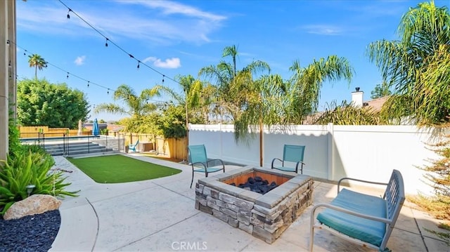 view of patio featuring an outdoor fire pit and a fenced backyard