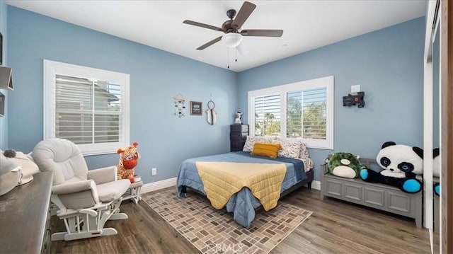 bedroom with a ceiling fan, baseboards, and wood finished floors