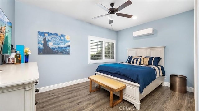 bedroom with ceiling fan, a wall mounted air conditioner, wood finished floors, and baseboards