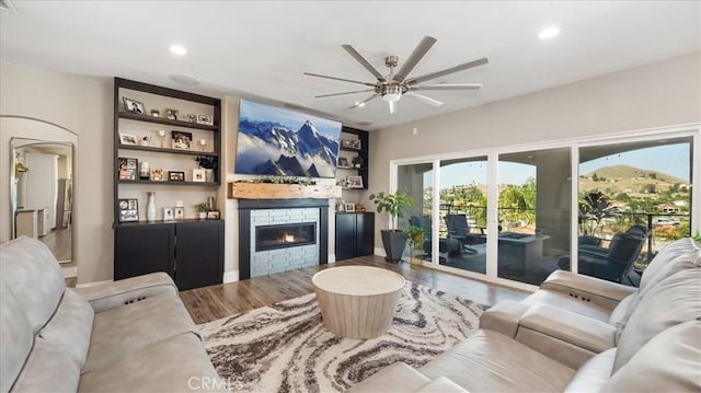 living room with a ceiling fan, recessed lighting, a fireplace, and wood finished floors